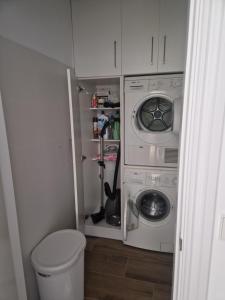 uma pequena casa de banho com máquina de lavar e secar roupa em Santika em Saint-Jean-de-Luz