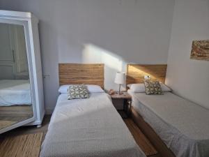 a small bedroom with two beds and a mirror at Santika in Saint-Jean-de-Luz
