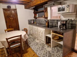 a kitchen with a counter and a table and a microwave at Charmante petite grange - 5 Couchages in Nalzen
