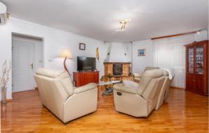 uma sala de estar com duas cadeiras e uma televisão em Gorgeous Home In Krasica With House Sea View em Krasica