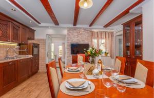 ein Esszimmer mit einem Tisch und einer Küche in der Unterkunft Gorgeous Home In Krasica With House Sea View in Krasica