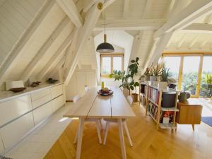 een keuken en eetkamer met een houten tafel bij Attic Apartment 2 Bedrooms in Crissier