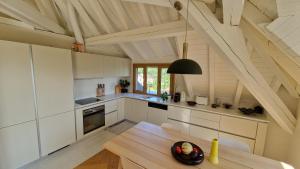 a kitchen with white cabinets and a wooden table at Attic Apartment 2 Bedrooms in Crissier