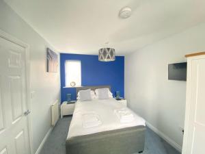 a bedroom with a bed with a blue wall at Arthur's Retreat in Filey +45 photos