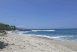 una playa de arena con olas en el océano en Casa Anez, en Cabuya
