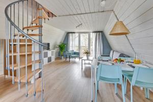 a room with a staircase and a table and chairs at Soul Camp Nowęcin in Łeba