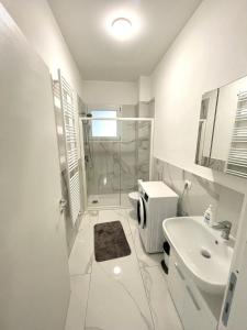 uma casa de banho branca com um chuveiro e um lavatório. em Isole em Baveno