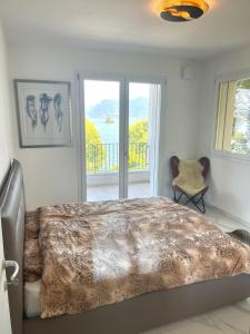 um quarto com uma cama grande e uma varanda em Isole em Baveno