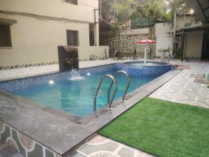 a swimming pool with an umbrella in a building at Rajdhani Resort Lonavala in Lonavala