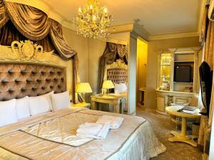 a bedroom with a large bed and a chandelier at Royal SPA & Hotel Resort in Rīga