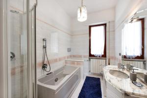 a white bathroom with a tub and a sink at Due passi dal mare tra gli ulivi in Varazze +22 photos