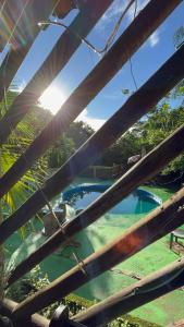 uma vista para uma piscina a partir de uma cerca de madeira em Suíte serra dos órgãos guapimirim em Guapimirim