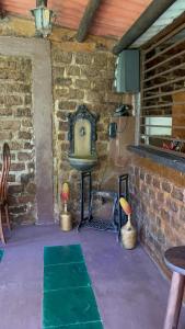 um quarto com uma parede de pedra, uma mesa e um lavatório em Suíte serra dos órgãos guapimirim em Guapimirim