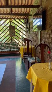 Pokój z dwoma stołami i żółtą tkaniną w obiekcie Suíte serra dos órgãos guapimirim w mieście Guapimirim