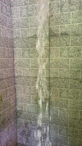 uma fonte de água numa casa de banho com uma parede de tijolos em Suíte serra dos órgãos guapimirim em Guapimirim