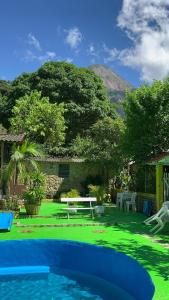 um quintal com uma piscina com uma mesa e um banco em Suíte serra dos órgãos guapimirim em Guapimirim