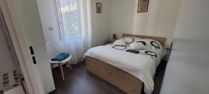 a small bedroom with a bed and a chair at Appartement Port-Mer près des plages in Cancale