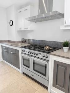 a kitchen with a stainless steel stove top oven at Stylish 3 Bedrooms in London