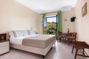 um quarto com uma cama, uma mesa e cadeiras em Hotel Desiree em Sorrento