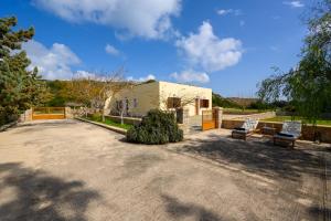 a building with two benches in a driveway at Hermes' Getaway Plimmiri in Plimmiri