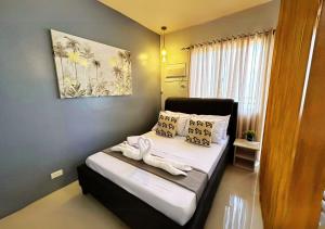 - une petite chambre avec un lit et des serviettes dans l'établissement Elegant 1BR with Balcony, FREE POOL & Gym near Puerto Princesa Airport - 5Topaz, à Puerto Princesa