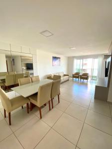 uma grande sala de estar com mesa e cadeiras em Apartamento até 8 Pessoas Praia Grande - Le Bon Vivant em Arraial do Cabo