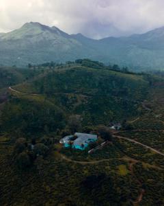 an aerial view of a house in the middle of a mountain at Ward80 Wayanad in Vythiri