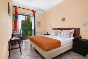una camera con un grande letto e un balcone di Hotel Desiree a Sorrento