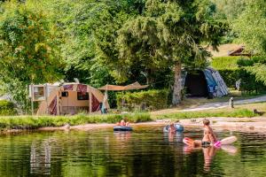 a group of people in the water at a camp site at Budget Glamping Safaritent La Sténiole in Barbey-Séroux