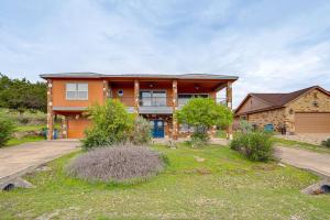 a large house with a driveway in front of it at Lago Vista Vacation Rental - Walk to Lake Travis! in Lago Vista