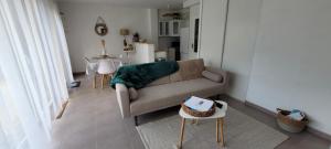uma sala de estar com um sofá e uma mesa em Appartement Port-Mer près des plages em Cancale