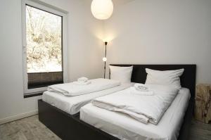 two twin beds in a room with a window at naturnah, mit Terrasse, Garten und Meerblick - Ferienwohnung auf dem Teschenberg in Middelhagen