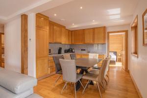 eine Küche und ein Esszimmer mit einem Tisch und Stühlen in der Unterkunft Grand Paradis- Modern 3 bedroom apartment with spectacular views in Chamonix-Mont-Blanc