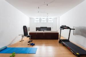a living room with a treadmill and a bed at [Villa Fenice] Swimming Pool, big garden & Gym in Nurachi
