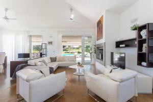 a living room with white couches and a tv at [Villa Fenice] Swimming Pool, big garden & Gym in Nurachi