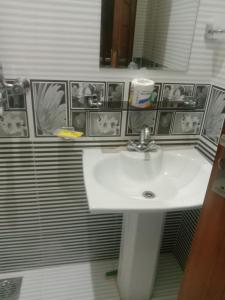 a bathroom with a white sink and a mirror at Gujrat Guest House in Gujrāt