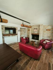 sala de estar con sofá rojo y chimenea en La Baita Del Cervo, en Castel di Sangro
