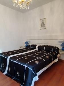 uma cama preta e branca num quarto com um lustre em Roma27 Scarperia em Scarperia
