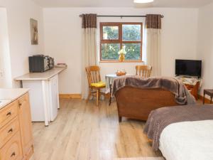 1 dormitorio con cama, mesa y cocina en Wheatfield Lodge en Fethard on Sea