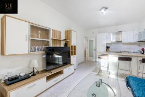 un soggiorno con grande TV e una cucina di Spacious, central APT in Paceville/St Julians by 360 Estates a San Giuliano