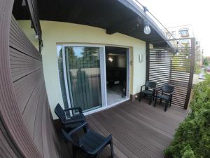 a deck with chairs and a sliding glass door at Grey in Jastrzębie Zdrój