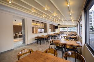 an empty restaurant with wooden tables and chairs at Nish Atakum Otel in Atakum