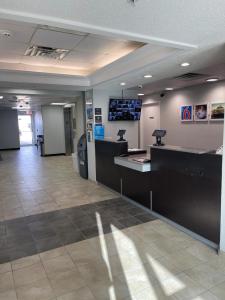 a lobby with a waiting room with a tv on the wall at Motel 6-Caseyville, IL - Caseyville Il in Caseyville