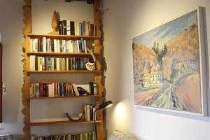 ein Wohnzimmer mit Bücherregalen mit Büchern in der Unterkunft Podere Massoli in San Casciano in Val di Pesa