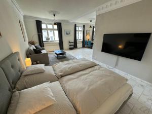 sala de estar con sofá y TV de pantalla plana en Art Apartments, en Hamburgo