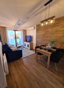 ein Wohnzimmer mit einem blauen Sofa und einem Tisch in der Unterkunft Nautikka Park Krynica Apartamenty Przy Plaży in Krynica Morska