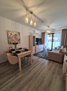 ein Wohnzimmer mit Tisch und Couch in der Unterkunft Nautikka Park Krynica Apartamenty Przy Plaży in Krynica Morska