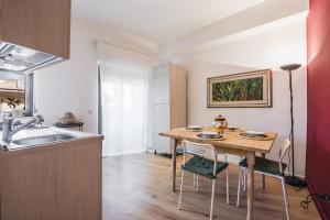 - une cuisine avec une table et des chaises en bois ainsi qu'un évier dans l'établissement Zafferana Apartment with Balcony by Wonderful Italy, à Zafferana Etnea