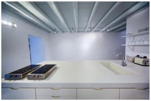 a white kitchen with a stove and a sink at La Galerie - Art House Parikia in Parikia