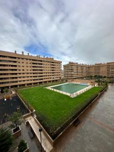 an apartment complex with a grassy courtyard with a swimming pool at El encanto de Seseña in Seseña